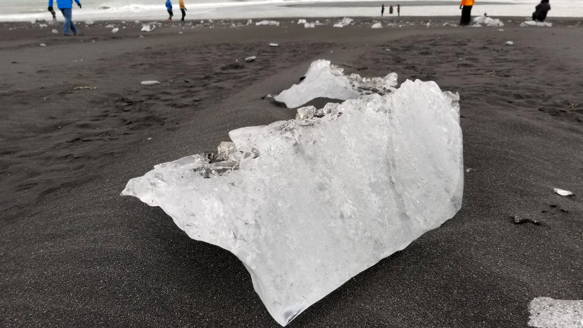 Pieces of ice glistening against the black sand at Diamond Beach in Iceland